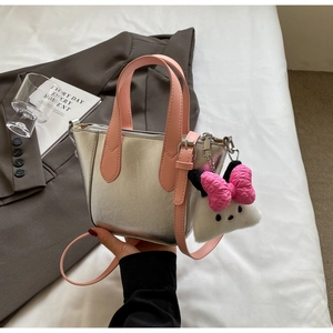 Detail of silver metallic handbag with pink handles and a cute plush bunny charm