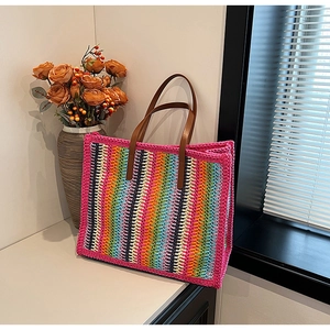 Detailed close-up of vibrant woven tote bag featuring colorful wavy patterns and leather handles