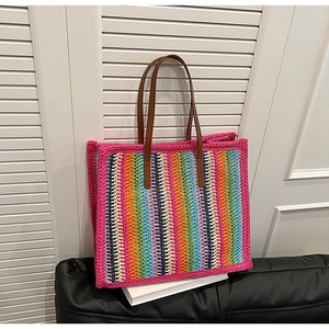Detail of colorful rainbow striped crochet tote bag with brown faux leather handles