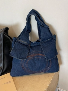 Retro denim tote bag with orange stitching and stone base presentation
