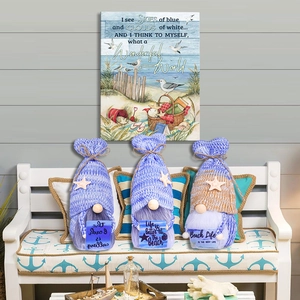 Three nautical summer gnomes with starfish hats and beach life signs on a white bench