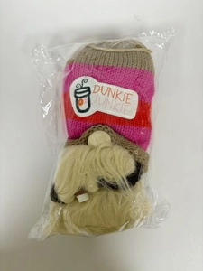 Détail d'un gnome de Noël café en peluche avec bonnet rayé tricoté dans un sac plastique