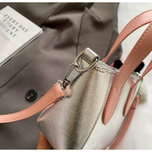 Detail of silver metallic PU leather bag with pink handle and durable metal hook buckle