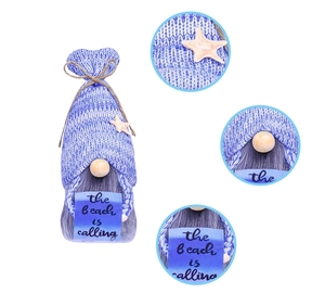Detail of knitted beach gnome with starfish accent and The Beach is Calling sign