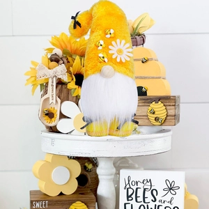 Macro view of plush bumblebee gnome with white beard, daisy hat, and rustic spring decor