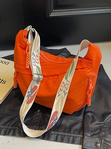 Orange nylon hobo crossbody bag with floral jacquard strap and crescent design