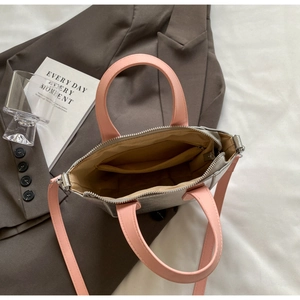 Internal view of silver tote bag showing spacious interior with pink strap detail