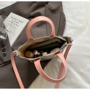 Internal view of a mini two-tone bucket bag showing space for phone and cosmetics