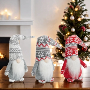 Three Christmas gnomes with snowflake knit hats standing on a rustic wooden table