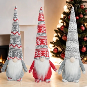 Three Christmas faceless gnomes with snowflake knit hats set against warm festive lights