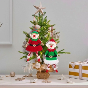 Detail of cute Christmas elf couple plush pendants with bells on a festive tree