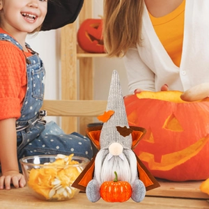 Detail of Halloween gnome with plush bat hat, vampire fangs and realistic pumpkin