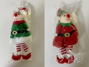Detail view of plush Christmas elf ornaments in red and green festive outfits