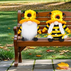 Adorable bee gnome couple ornaments with sunflower hats on a rustic wooden bench outdoors