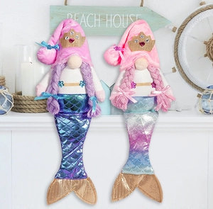 Detail of mermaid gnome plush dolls with sequined tails and seashell beach house decor