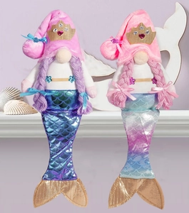 Detail of two mermaid-themed plush gnomes with sequined tails and seashell decorations
