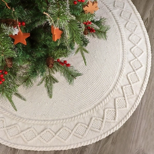 Ivory white cable knit Christmas tree skirt with textured diamond pattern on wood floor
