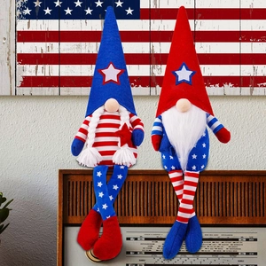 Pair of July 4th gnome plush dolls with stars and stripes on a rustic wood background