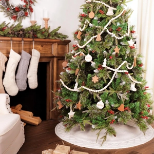 White knitted Christmas tree skirt with assorted wooden snowflake and star ornaments