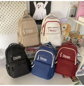 Detailed arrangement of five multi-colored nylon backpacks for students on a desk