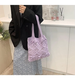 Détail du sac cabas en tricot violet avec texture ajourée et nœuds portés par le mannequin