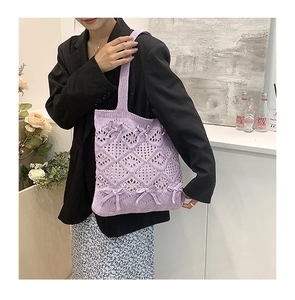Détail du sac cabas en tricot violet avec texture ajourée et nœuds en relief
