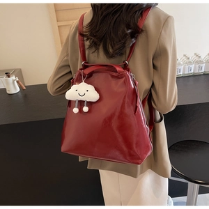 Dark red PU leather backpack for women with a cute white cloud pendant on a model