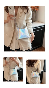 Close-up of holographic silver crossbody bag featuring pearl pendant and metal chain