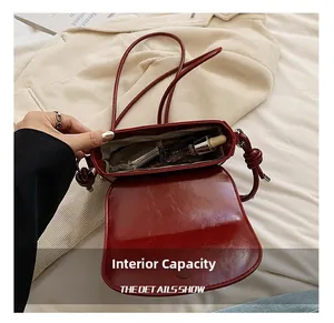 Internal capacity of red saddle bag showing magnetic closure and storage space