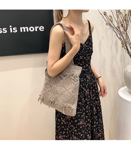 Gros plan d'un sac cabas en tricot beige avec motifs ajourés et petits nœuds