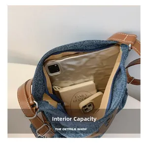 Internal view of the denim shoulder bag showing large capacity and zipper details