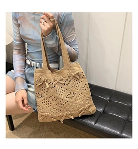 Détail du sac fourre-tout en crochet beige avec nœuds sur les genoux d'un mannequin