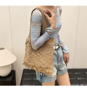 Détail d'un sac cabas en maille ajourée avec nœuds, porté par un mannequin en studio