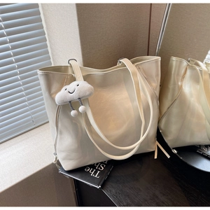 Detail of cream tote bag in shiny PU leather with cute plush cloud smiley charm