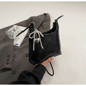 Glossy black PU crescent handbag with pearl bow charm and silver heart pendant detail