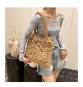 Gros plan détaillé du sac cabas au crochet kaki avec motifs ajourés et petits nœuds