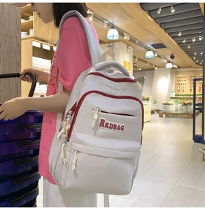 Detail of white nylon backpack with red contrast zippers and RKDBAG embroidery patch