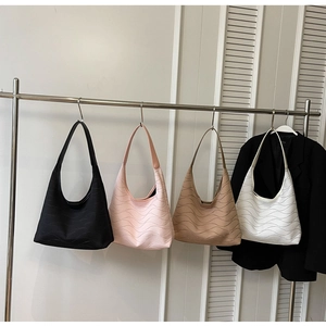 Detail showing wavy textured synthetic leather hobo bags in four colors on a metal hanger