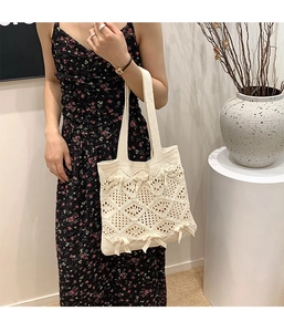 Détail du sac cabas en tricot ajouré avec des nœuds doux et des motifs texturés