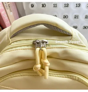 Detail of smooth double zippers and woven pulls on a yellow college backpack