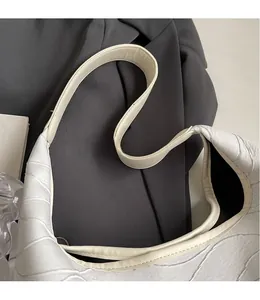 Detail of white crocodile pattern tote bag with smooth long shoulder strap and leather texture