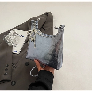 Detail of silver metallic wrinkled texture shoulder bag with pearl bow and heart charm