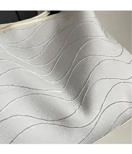 Close-up of light grey tote bag fabric with wave stitching and premium white piping details