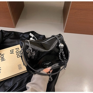 Détail du sac en cuir plissé brillant avec plaque logo argentée et breloque cheval