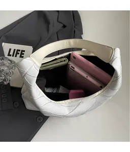 Detail view of large white quilted tote bag showing spacious interior for tablets