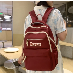 Detail view of the red nylon backpack showing its large capacity and durable zipper pocket