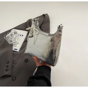 Detail of silver metallic wrinkled texture handbag with pearl bow pendant decoration