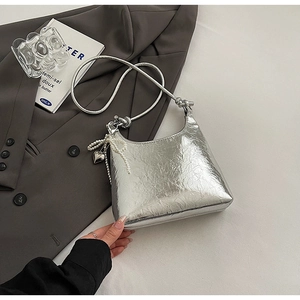 Detail of silver metallic bucket bag with pleated texture and pearl bow charm