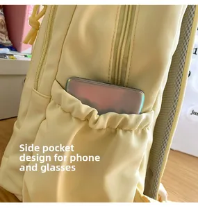 Close-up of the elastic side pocket on a yellow backpack holding a smartphone