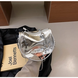 Détail du sac à main argenté effet métal liquide avec chaîne et breloque cheval